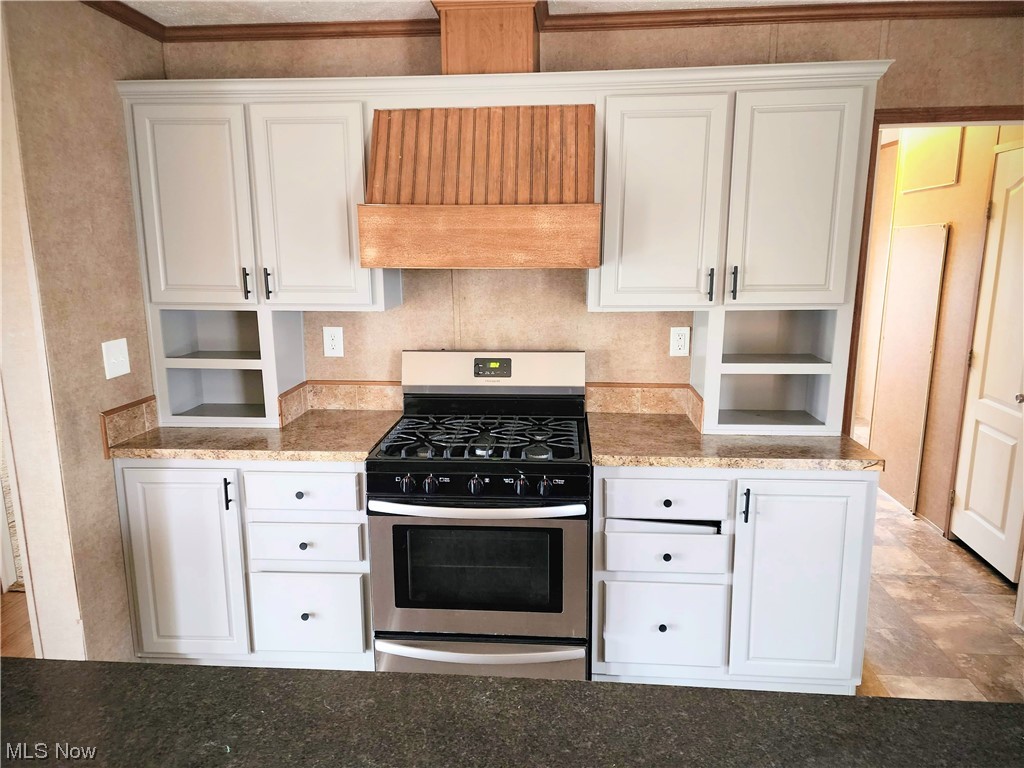 2925 Barth Road Belpre, OH 45714 - Photo 9 of 19 Kitchen featuring custom exhaust hood, light tile floors, stainless steel gas stove.