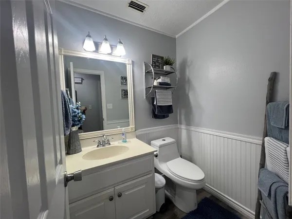a bathroom with a toilet a sink and mirror