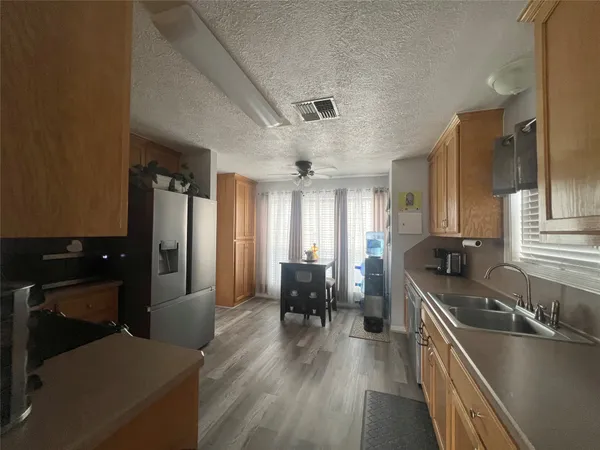 a kitchen with a sink appliances and wooden floor