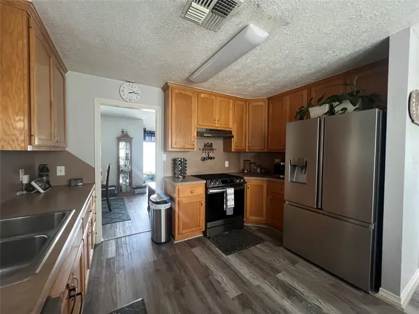 a kitchen with a refrigerator cabinets and wooden floor