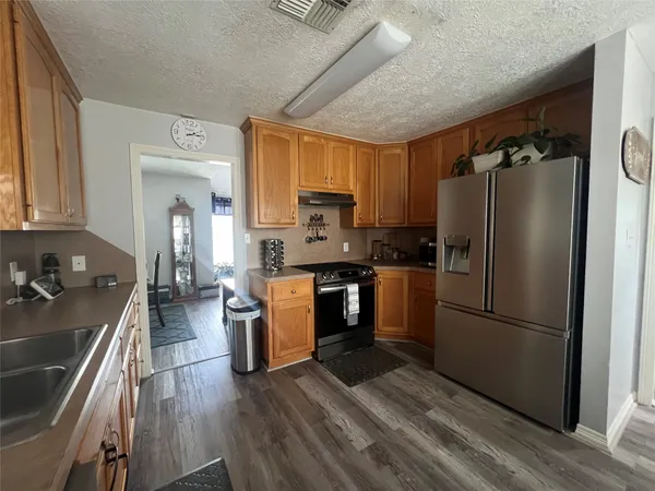 a kitchen with a refrigerator cabinets and wooden floor