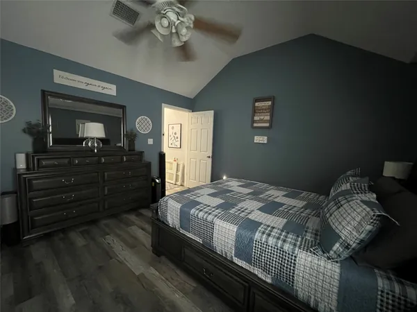 a bedroom with bed and wooden floor