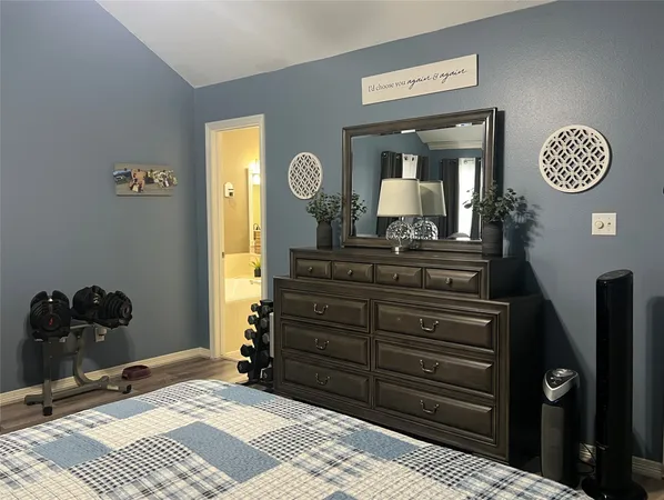 a bedroom with a bed and a mirror on dresser