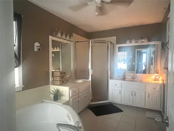 a spacious bathroom with a bathtub shower sink mirror and toilet