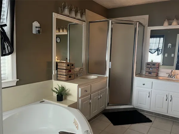 a bathroom with a tub sink and mirror