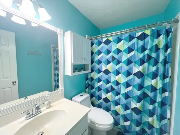 a bathroom with a sink mirror vanity and toilet