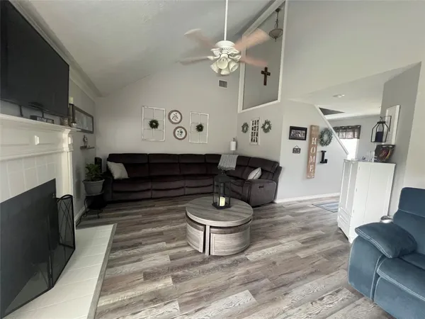 a living room with furniture a fireplace and a flat screen tv