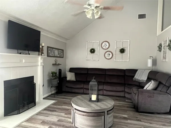 a living room with furniture a flat screen tv and a fireplace