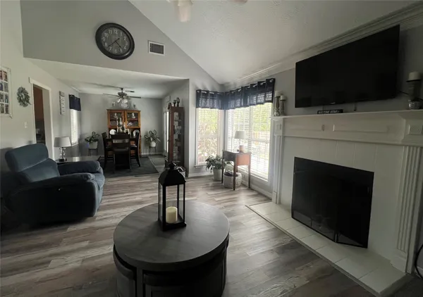 a living room with furniture a flat screen tv and a fireplace