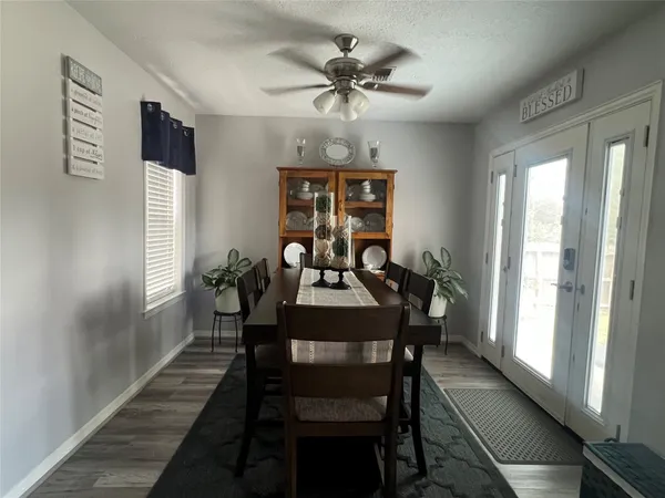 a view of a a dining room with furniture window and wooden floor