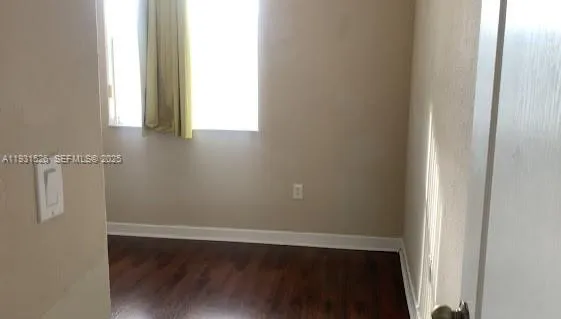 a view of a small space with wooden floor and a window