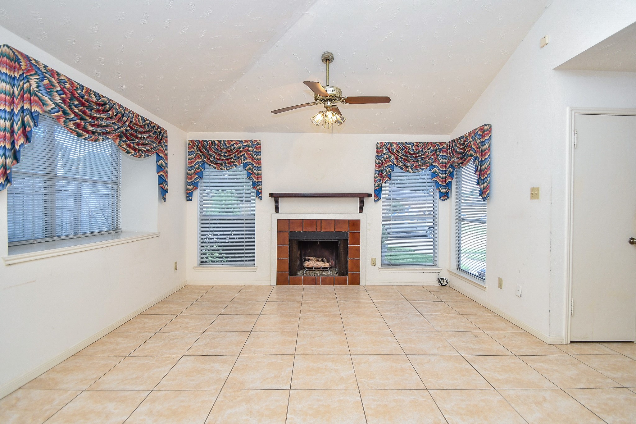 8323 East Ridge Drive Houston, TX 77040 - Photo 12 of 31 a view of an empty room with a fireplace and a window