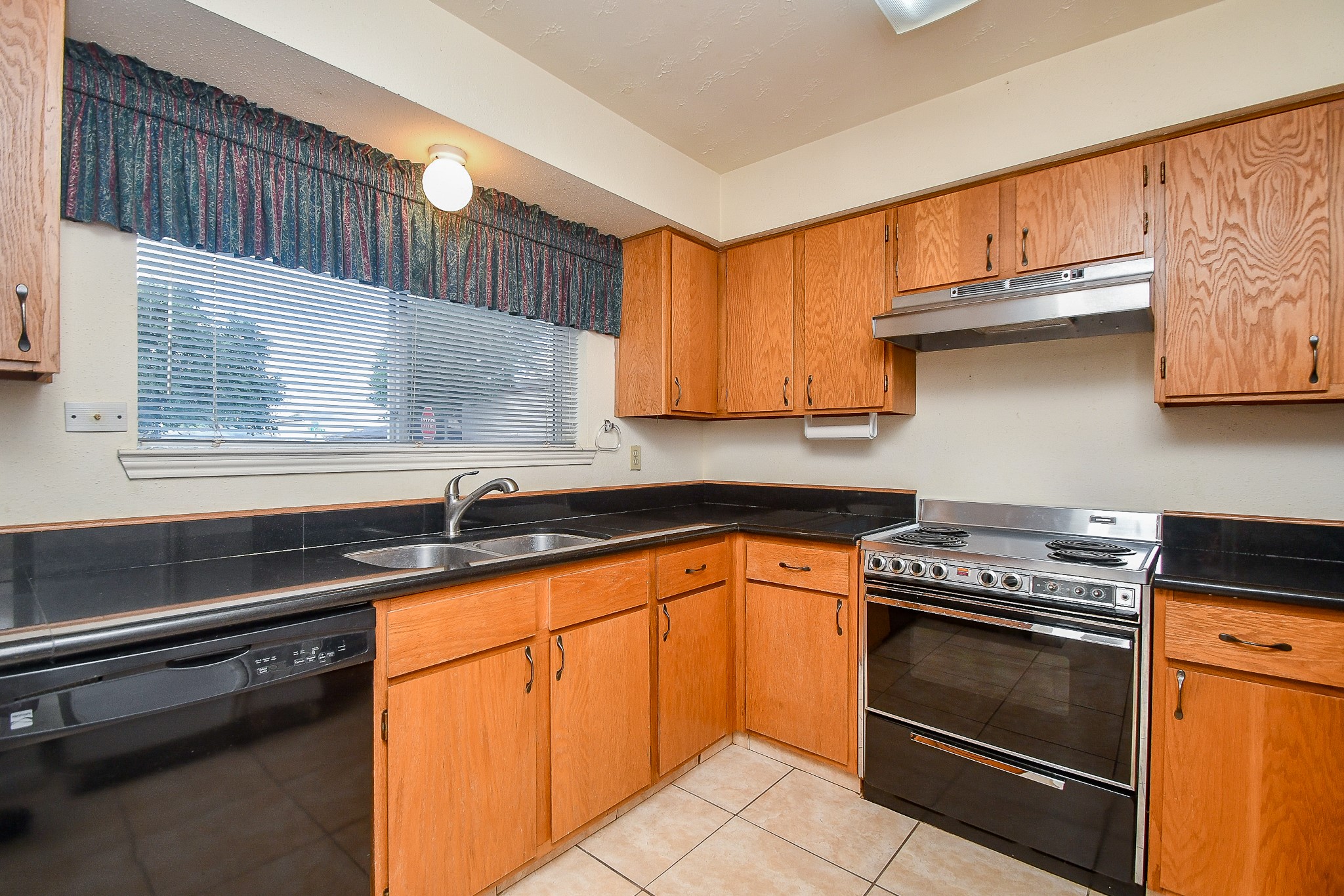 8323 East Ridge Drive Houston, TX 77040 - Photo 5 of 31 a kitchen with granite countertop a stove sink and cabinets