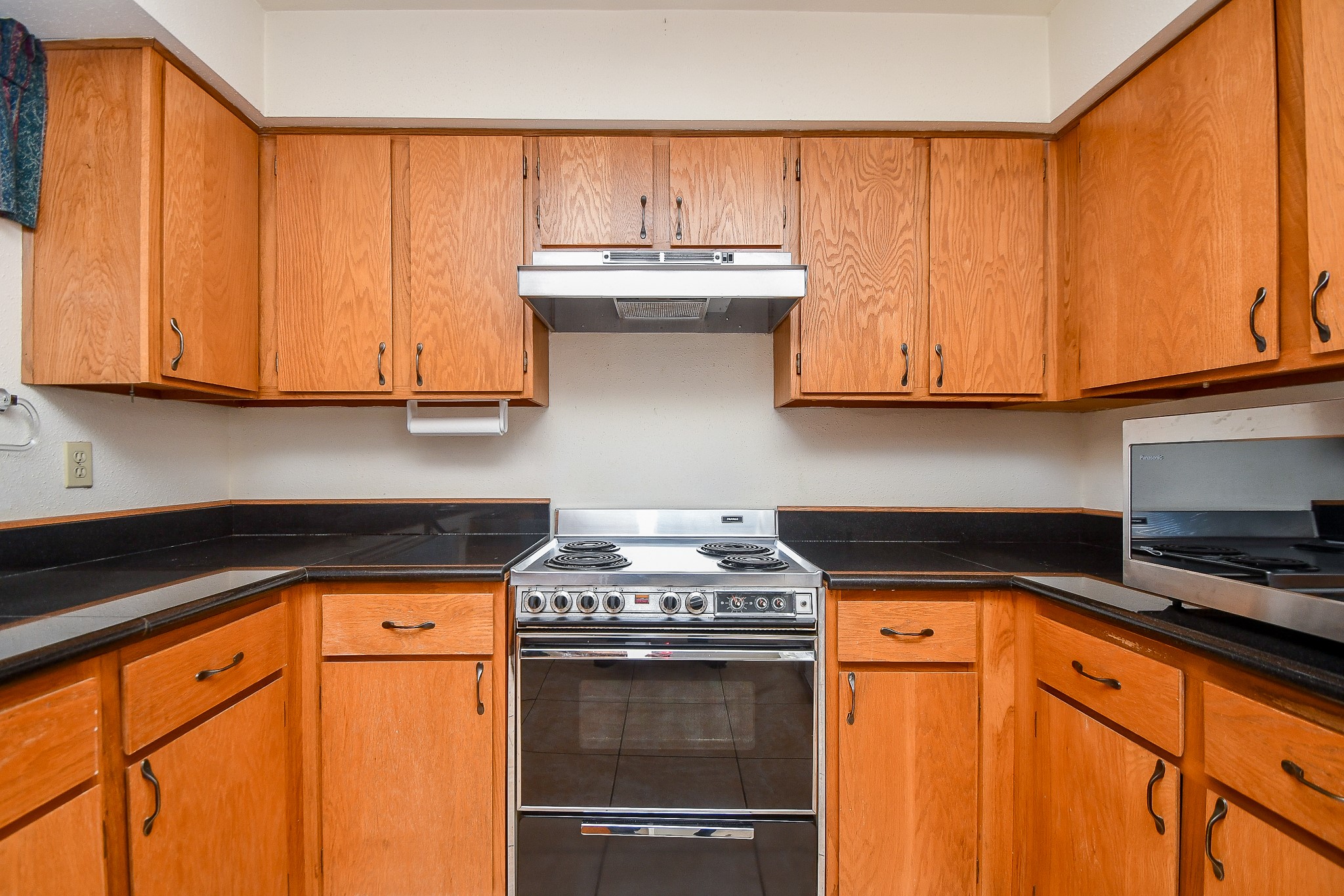 8323 East Ridge Drive Houston, TX 77040 - Photo 6 of 31 a kitchen with granite countertop wood cabinets and a stove top oven