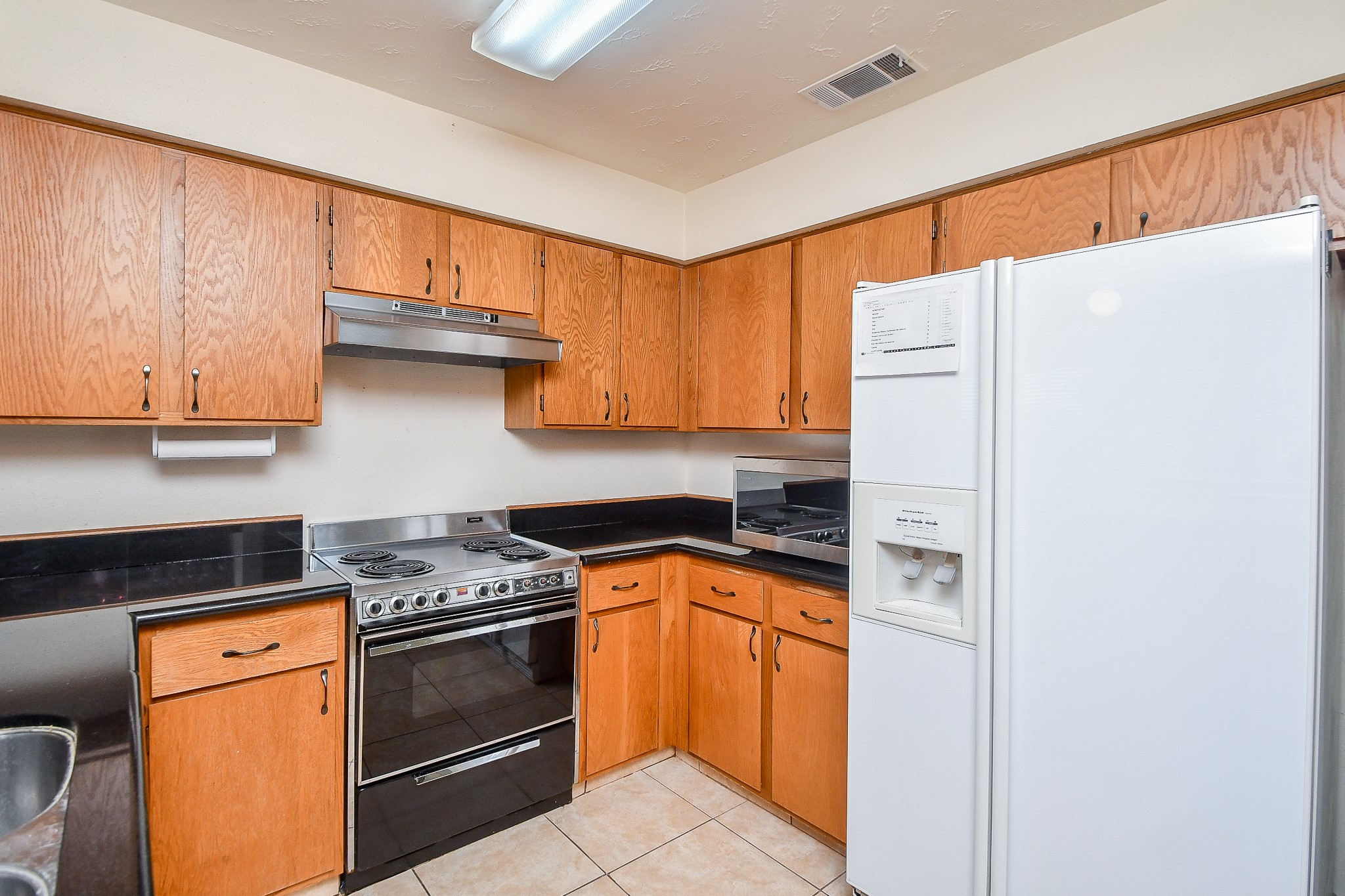 8323 East Ridge Drive Houston, TX 77040 - Photo 9 of 31 a kitchen with stainless steel appliances granite countertop a stove a sink and a refrigerator