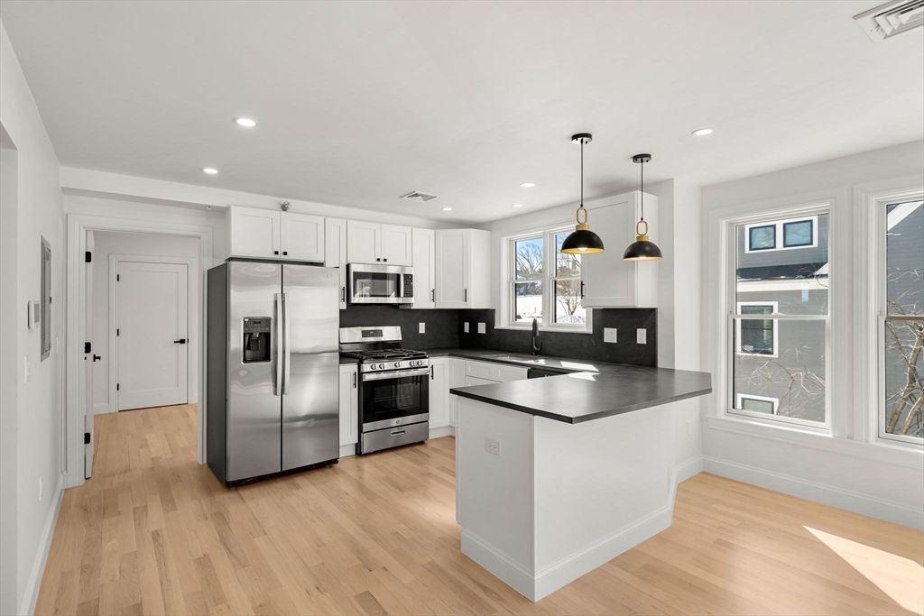 a kitchen with stainless steel appliances granite countertop a refrigerator and a stove top oven