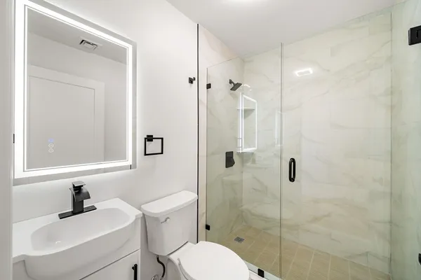 a bathroom with a sink toilet a mirror and shower