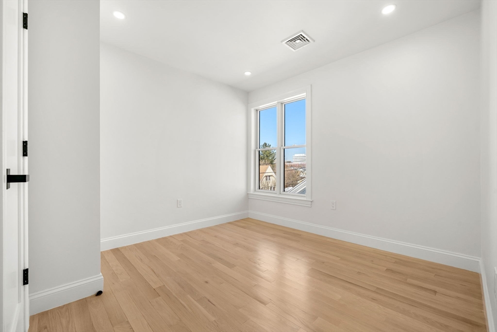 55 Dustin Street, Unit 3 Boston, MA 02135 - Photo 12 of 22 an empty room with wooden floor and windows