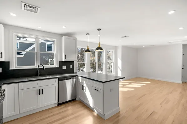 a kitchen with granite countertop a sink and cabinets