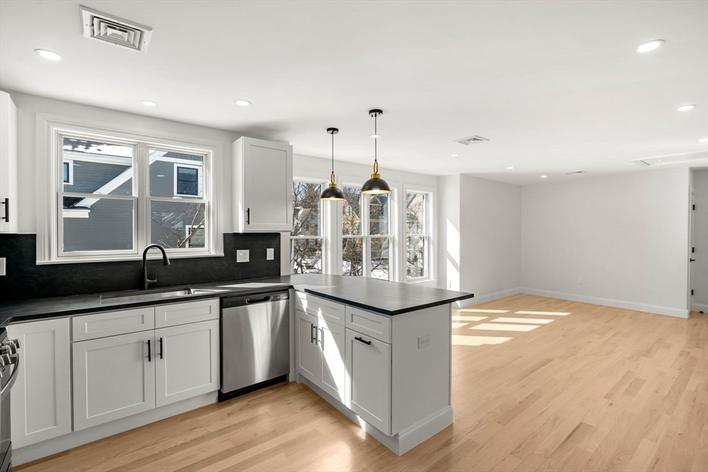 55 Dustin Street, Unit 3 Boston, MA 02135 - Photo 2 of 22 a kitchen with granite countertop a sink and cabinets