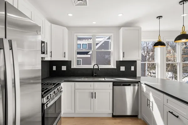 a kitchen with stainless steel appliances granite countertop a sink a stove and a refrigerator