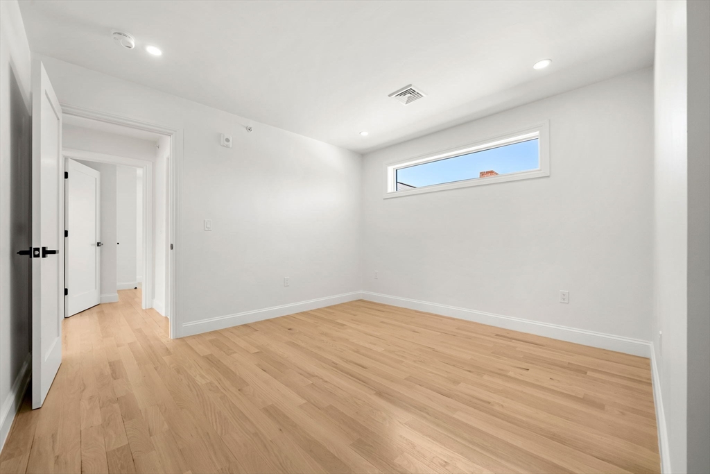55 Dustin Street, Unit 3 Boston, MA 02135 - Photo 9 of 22 wooden floor in an empty room with a window