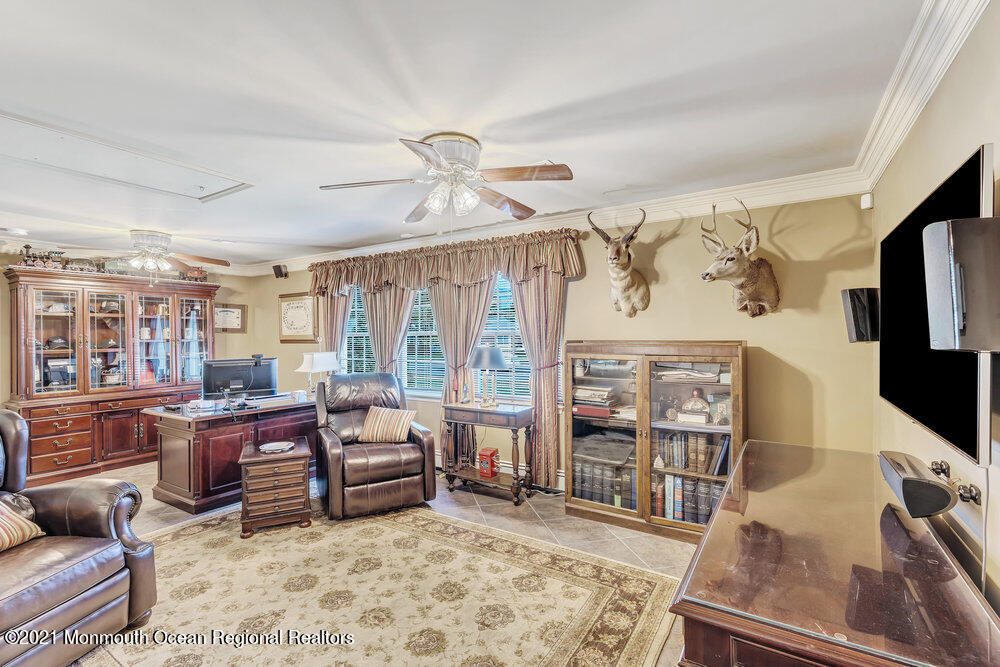 50 Lone Oak Road Middletown, NJ 07748 - Photo 30 of 38 a living room with furniture a flat screen tv and floor to ceiling window