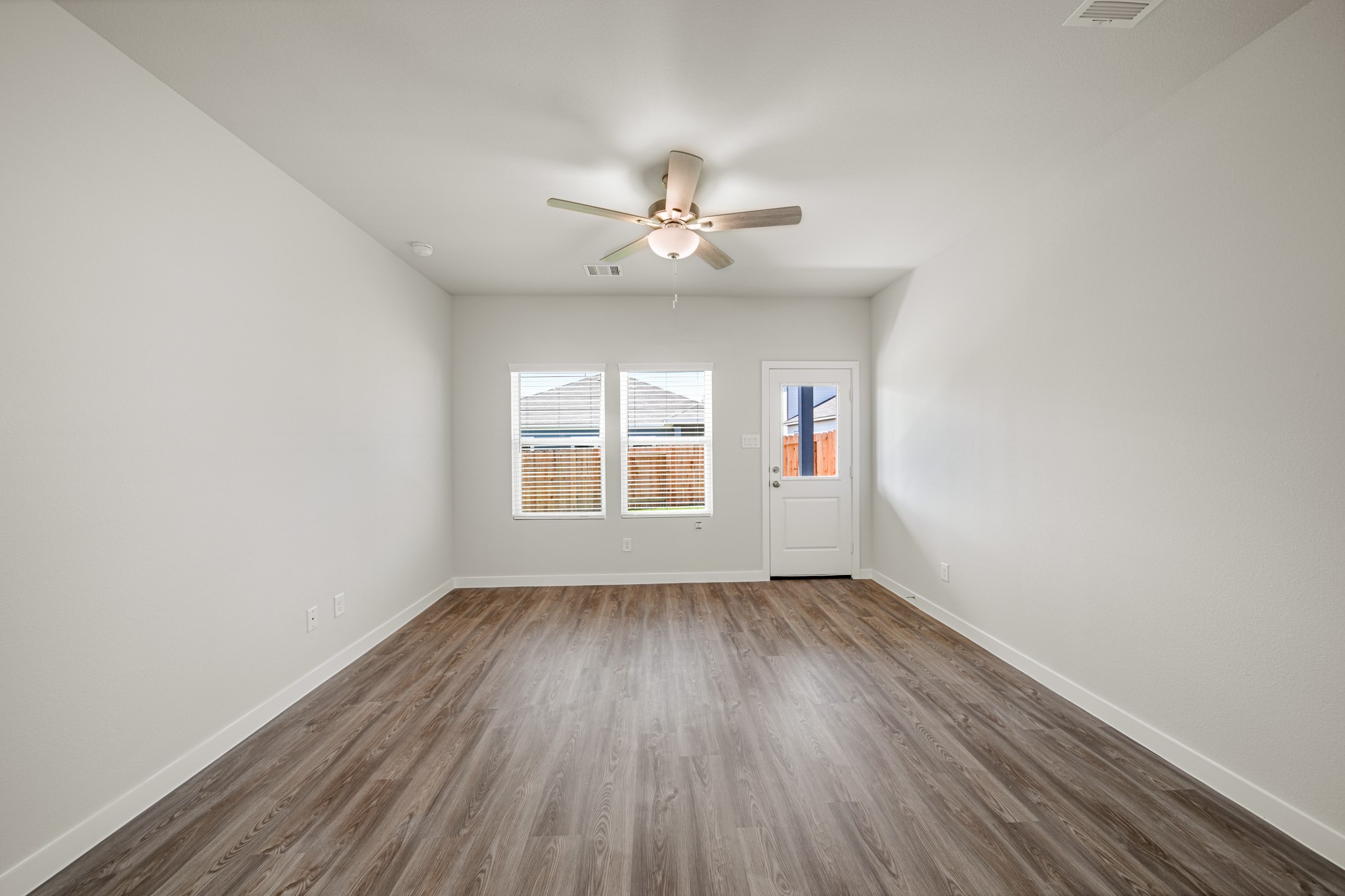 325 Bennett Street Angleton, TX 77515 - Photo 8 of 28 an empty room with wooden floor ceiling fan and windows