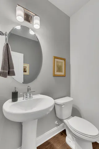 a bathroom with a toilet a sink and mirror