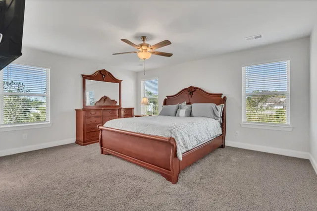 a bedroom with a bed dresser and a window