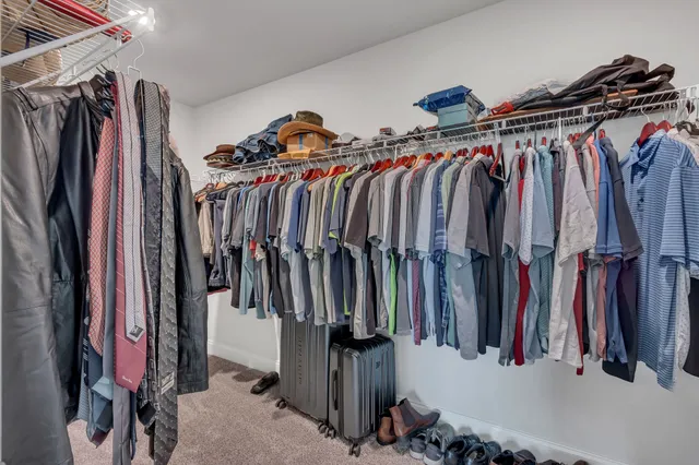 a view of walk in closet with clothes and shoes