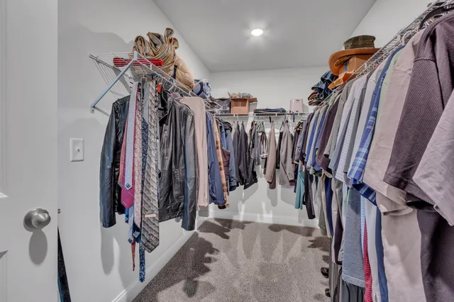 a view of walk in closet with clothes