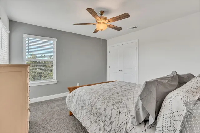 a bedroom with a large bed and a ceiling fan