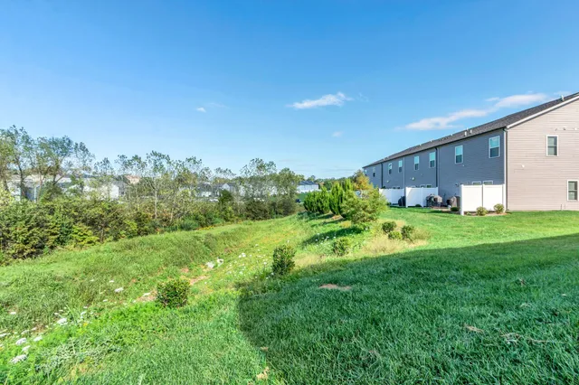 a view of a house with a big yard and large trees