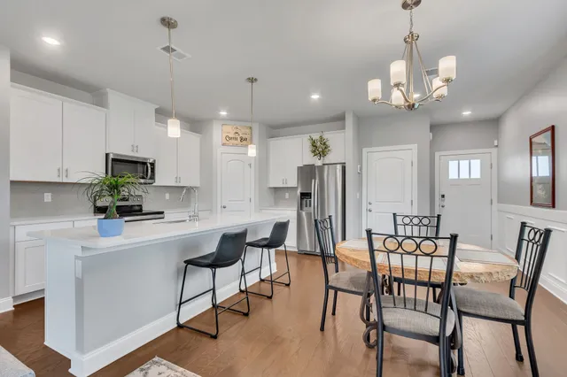 a view of a dining room with furniture a chandelier and wooden floor