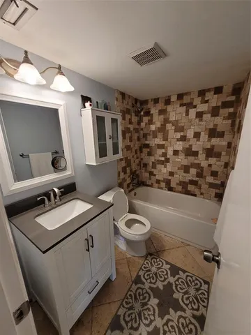 a bathroom with a sink toilet vanity and shower