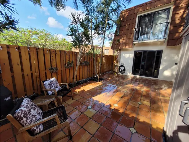 a backyard of a house with barbeque oven fire pit table and chairs