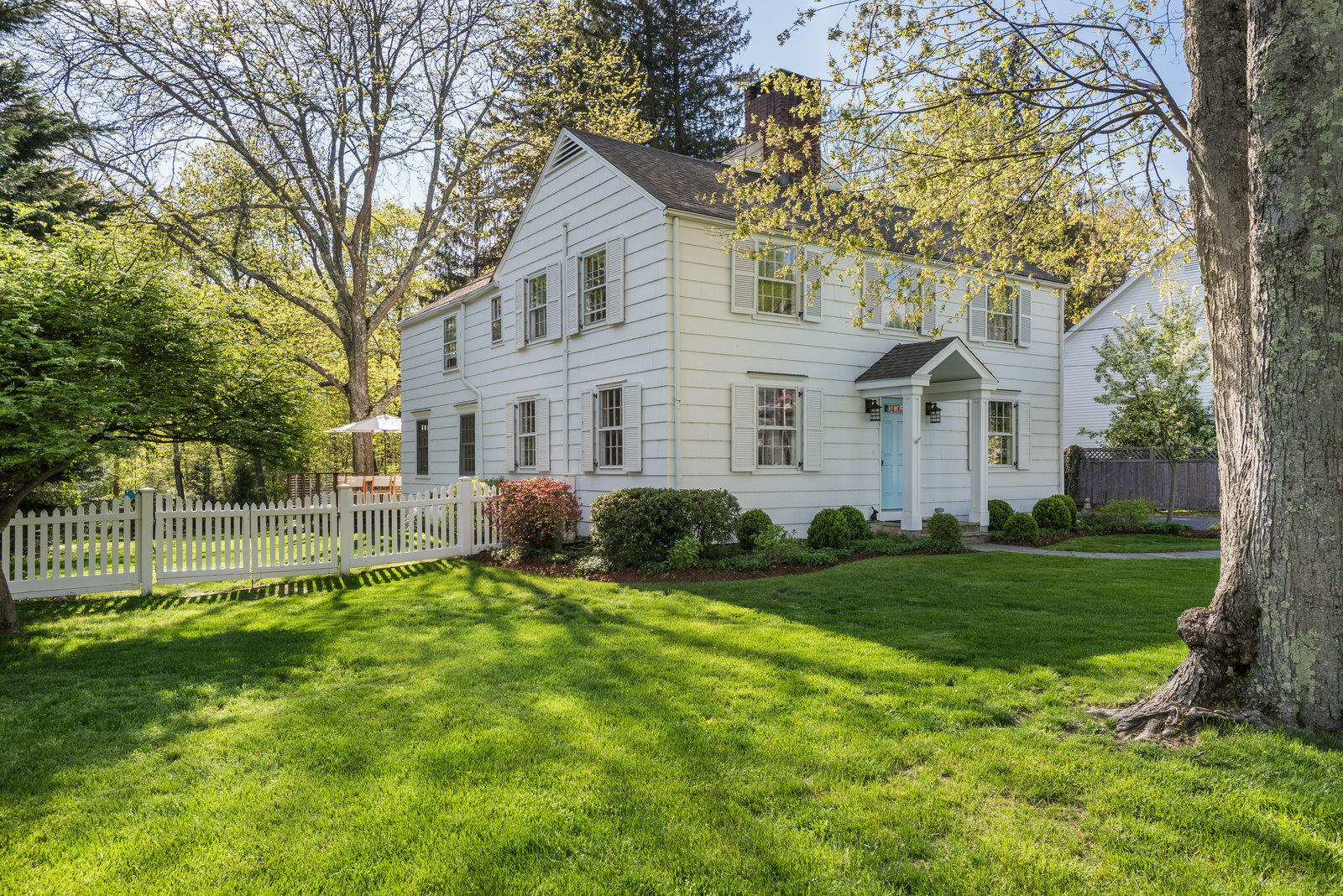 a front view of a house with a yard and trees