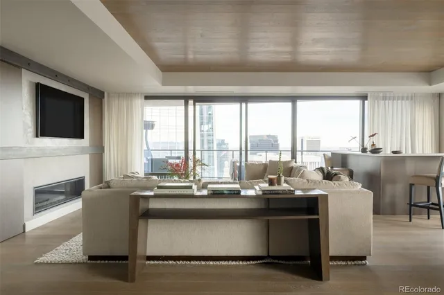 a room with kitchen island granite countertop a sink chairs and a fireplace