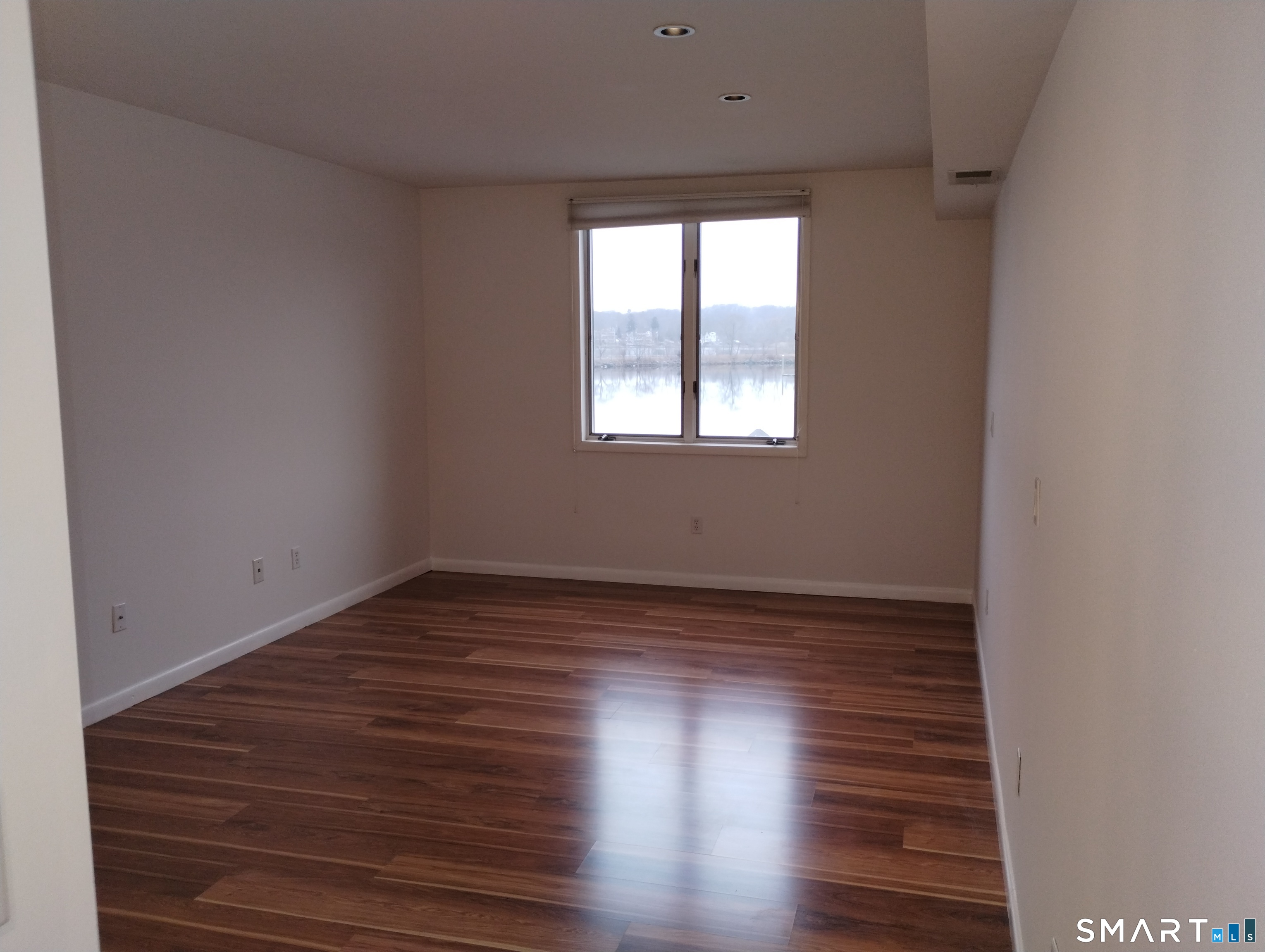 523 Popes Island Road, Unit 523 Milford, CT 06461 - Photo 15 of 33 a view of an empty room with wooden floor and window