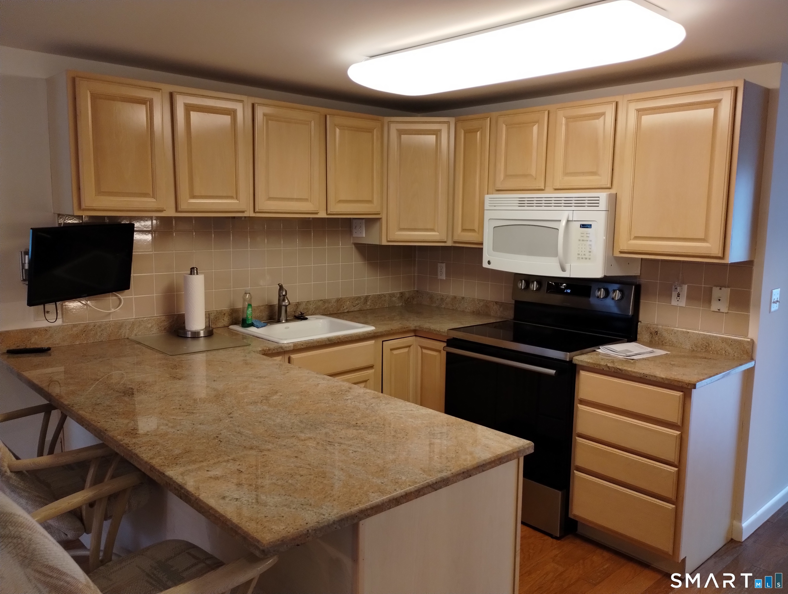 523 Popes Island Road, Unit 523 Milford, CT 06461 - Photo 6 of 33 a kitchen with a stove and a refrigerator