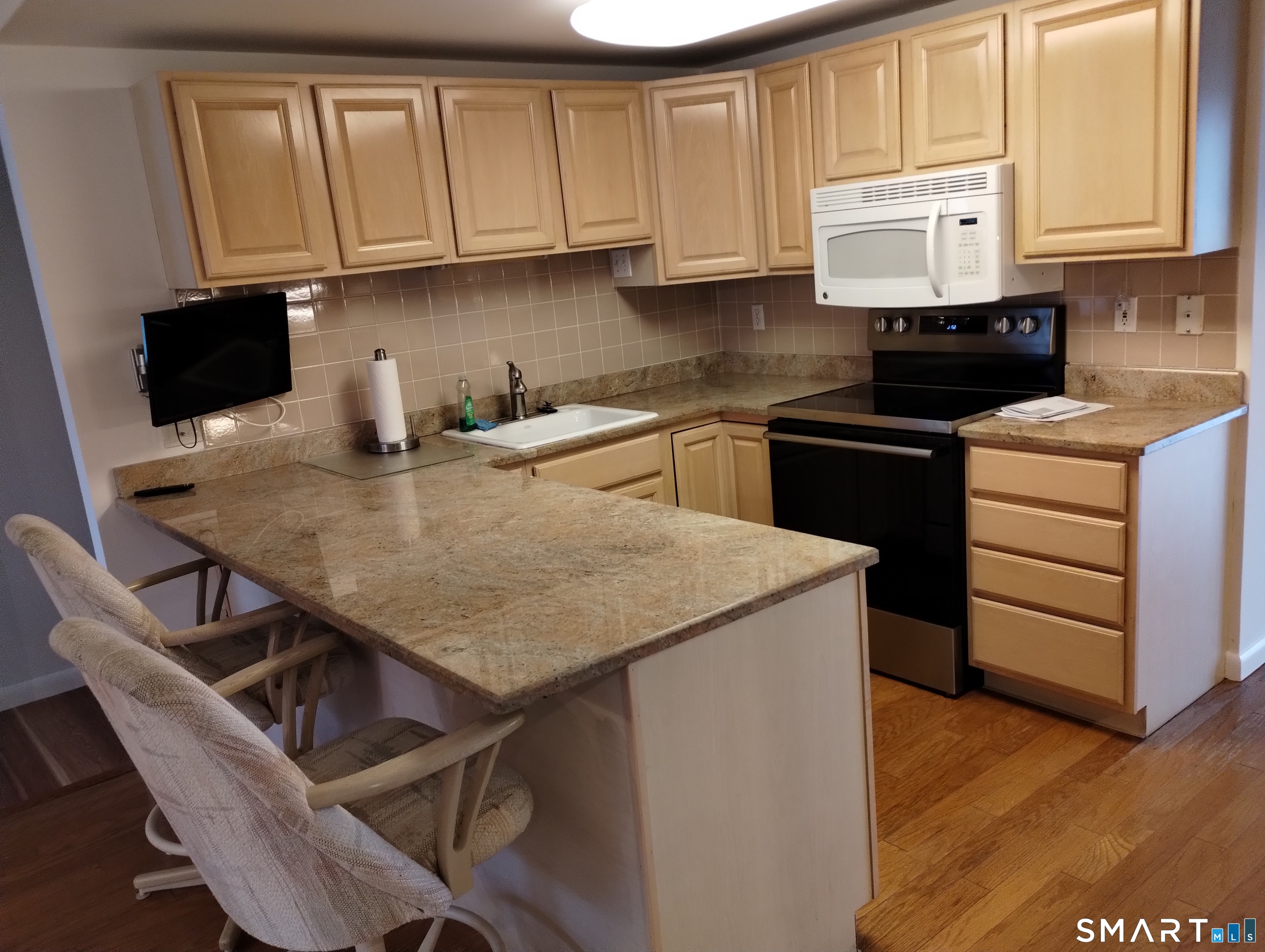 523 Popes Island Road, Unit 523 Milford, CT 06461 - Photo 7 of 33 a kitchen with stainless steel appliances granite countertop a stove a refrigerator a sink a stove and white cabinets