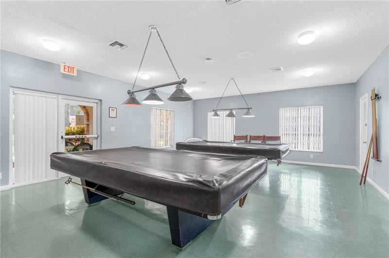 253 South Cypress Road, Unit 234 Pompano Beach, FL 33060 - Photo 11 of 15 a kitchen with stainless steel appliances a table chairs and wooden floor