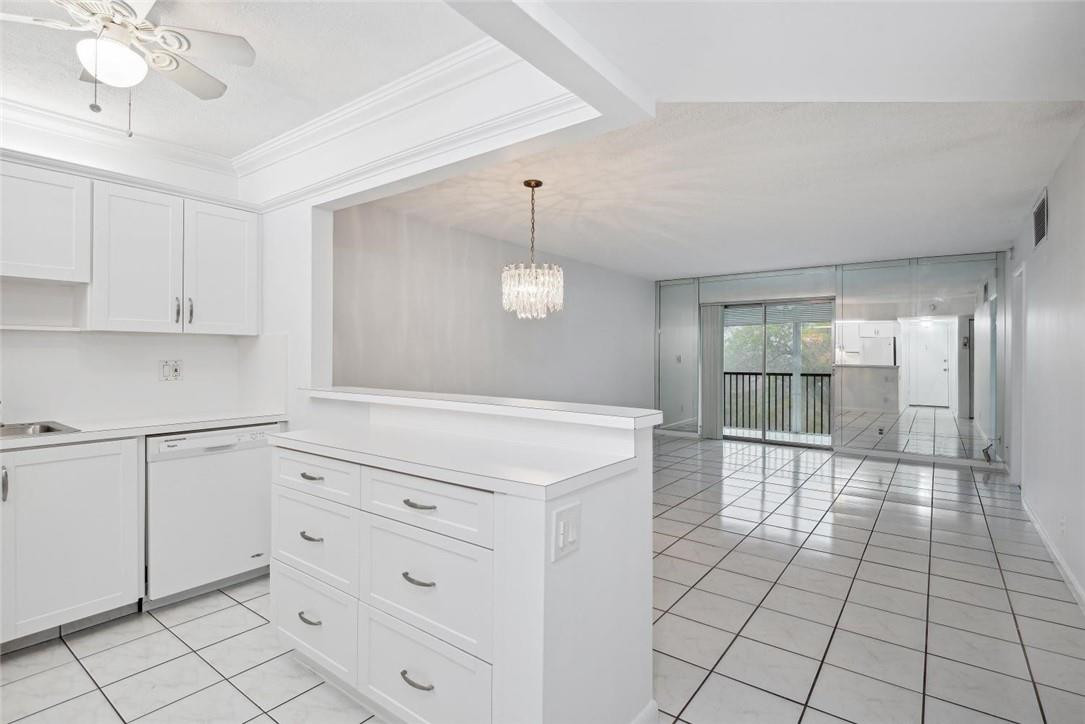 253 South Cypress Road, Unit 234 Pompano Beach, FL 33060 - Photo 2 of 15 a view of a kitchen with cabinet and an empty room