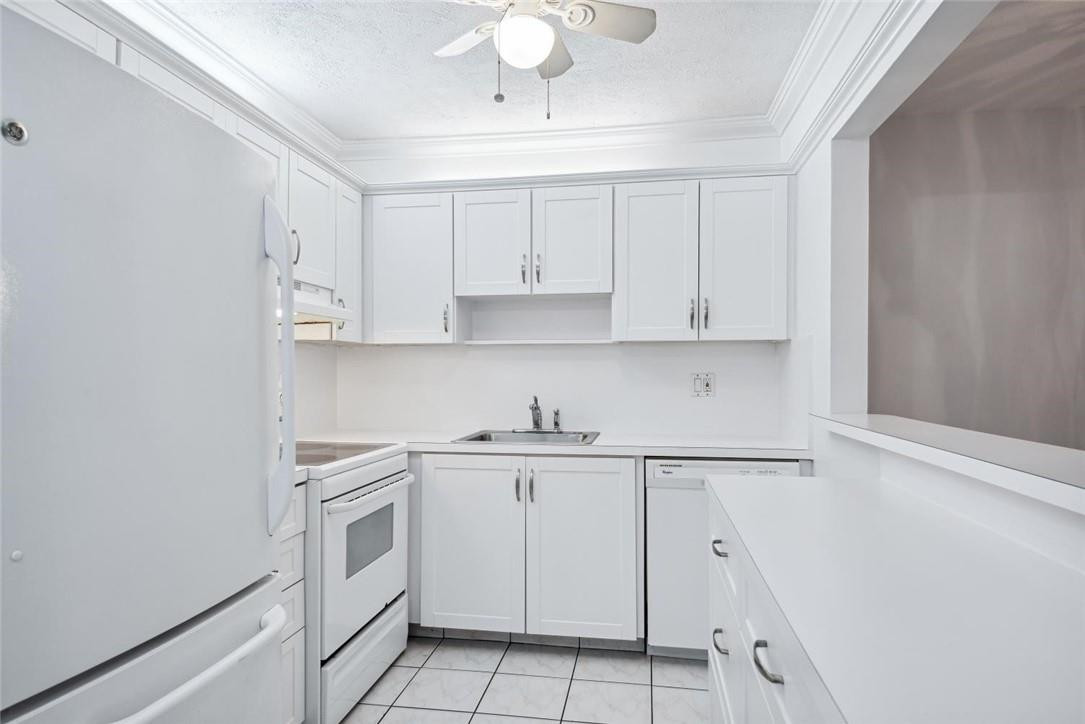 253 South Cypress Road, Unit 234 Pompano Beach, FL 33060 - Photo 3 of 15 a kitchen with white cabinets