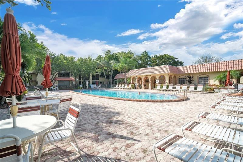 253 South Cypress Road, Unit 234 Pompano Beach, FL 33060 - Photo 8 of 15 a view of a house with swimming pool and sitting area