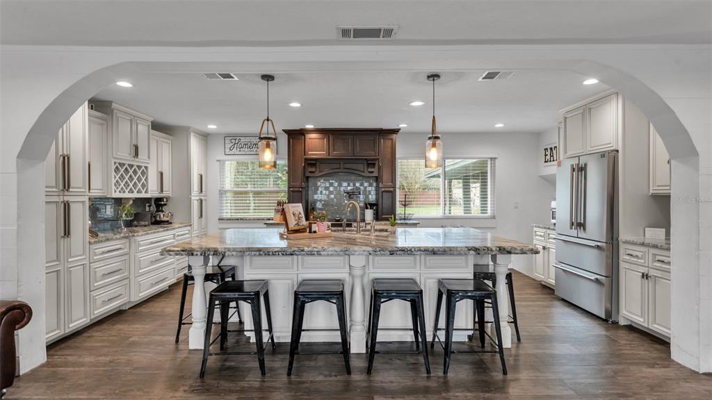 4623 Kings Point Court Lakeland, FL 33813 - Photo 29 of 61 a kitchen with stainless steel appliances kitchen island granite countertop a dining table chairs sink and cabinets
