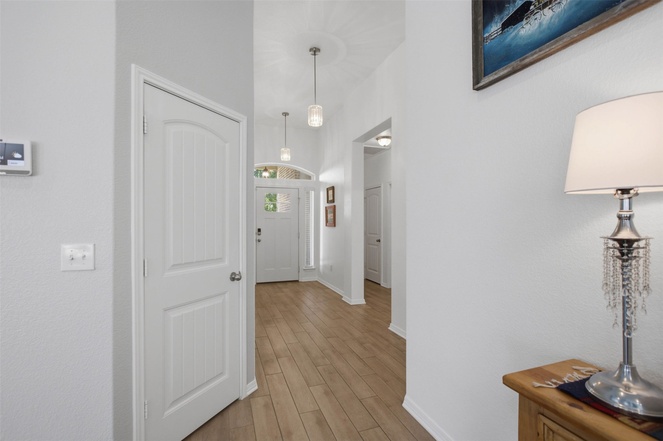 2413 Bridges Ranch Road Georgetown, TX 78628 - Photo 5 of 31 A well-lit entry hall with wood flooring and vaulted ceilings creates a welcoming pathway.