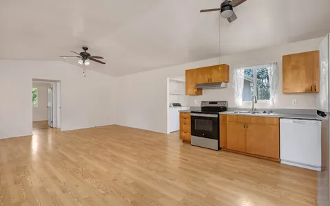 a kitchen with granite countertop a sink cabinets and stainless steel appliances