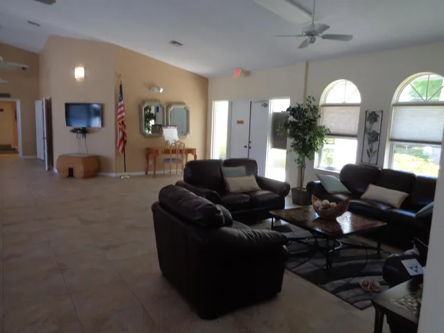 a living room with furniture a chandelier and a flat screen tv